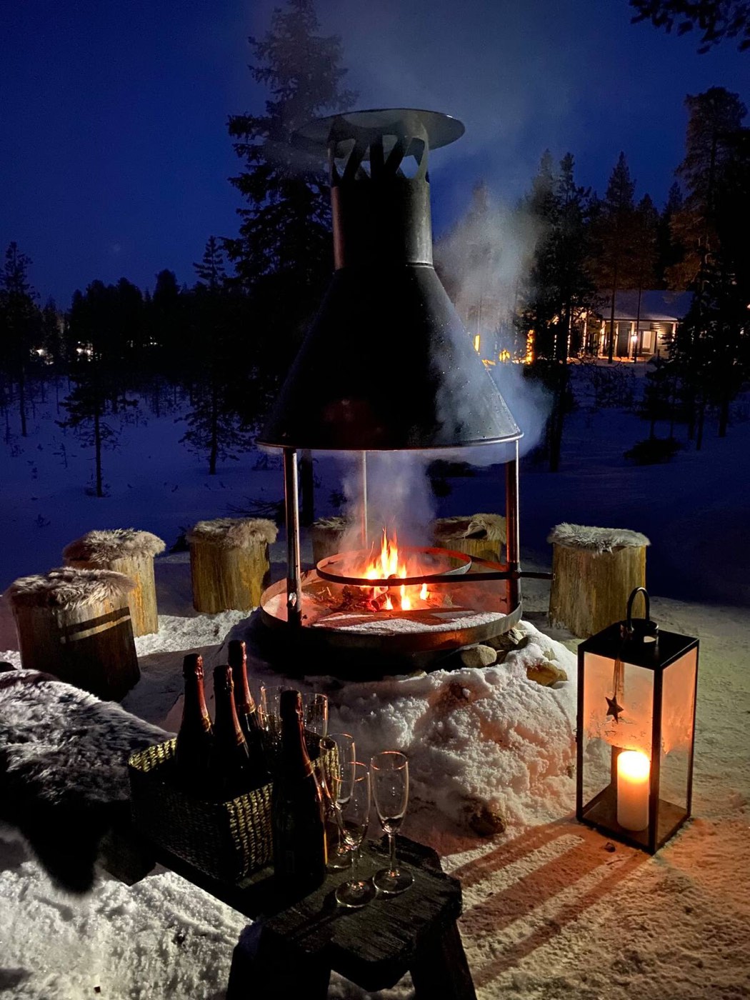Open fire in the barbecue hut with lanterns and snow outside