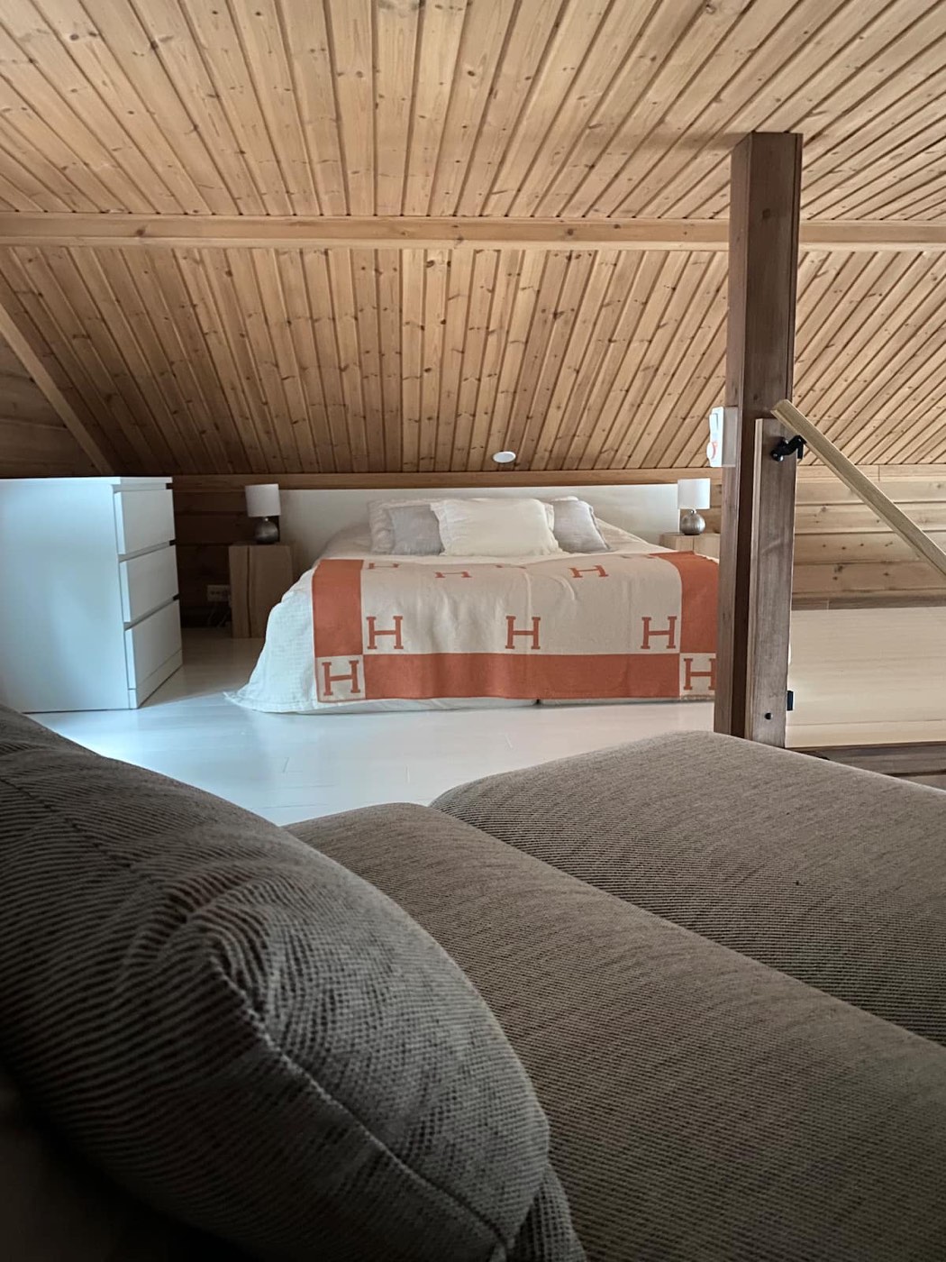 Bedroom 3, a queen bed under a sloping timber ceiling